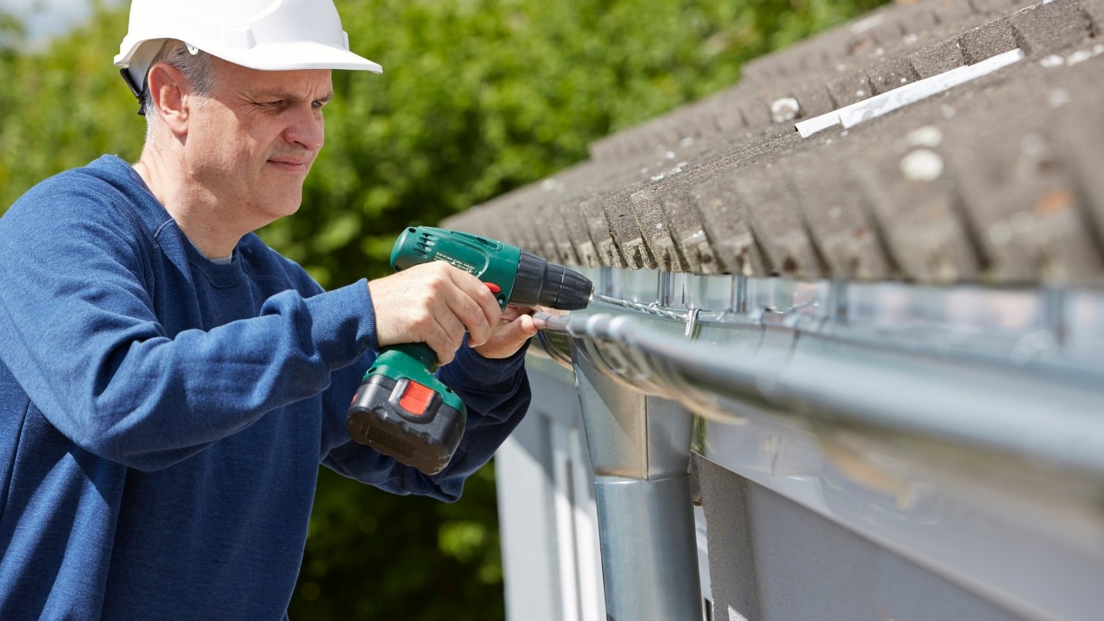 Worker replacing an old damaged gutter